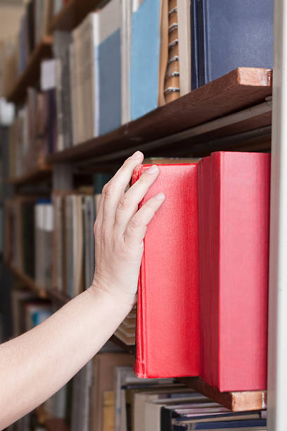 istock woman takes a book from the shelf 178618926
