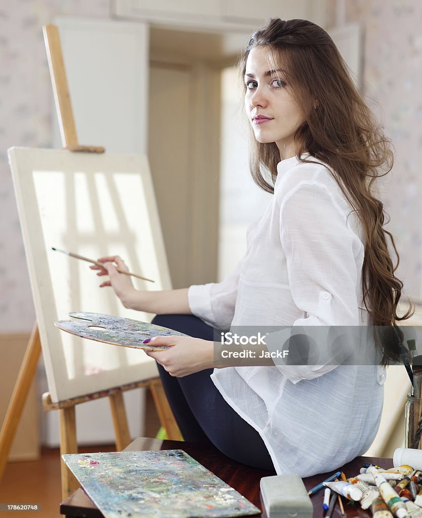 Long-haired kobieta z oleju kolory w pobliżu tablicy. - Zbiór zdjęć royalty-free (20-24 lata)
