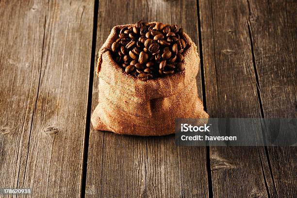 Granos De Café En La Bolsa En La Tabla Foto de stock y más banco de imágenes de Alimento - Alimento, Arpillera, Bebida