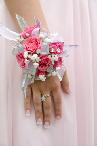 A teen girl with a wrist corsage on prom night.