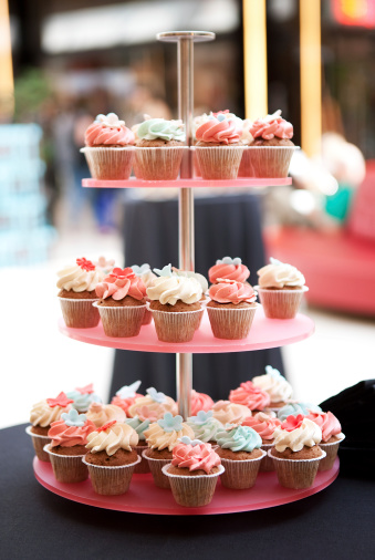 cupcakes tower with garnish white and pink icing on blur background