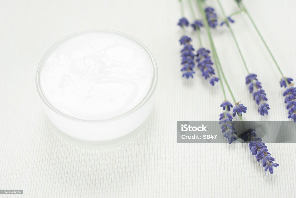 Cream, lavender flowers face cream and blue lavender flowers on white textile background Acne Cream Stock Photo