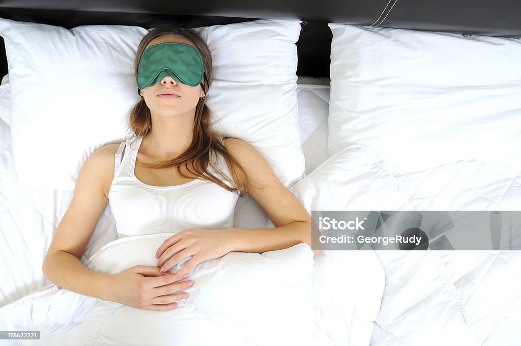 Woman sleep Woman lies with sleeping mask in the bed Eye Mask Stock Photo