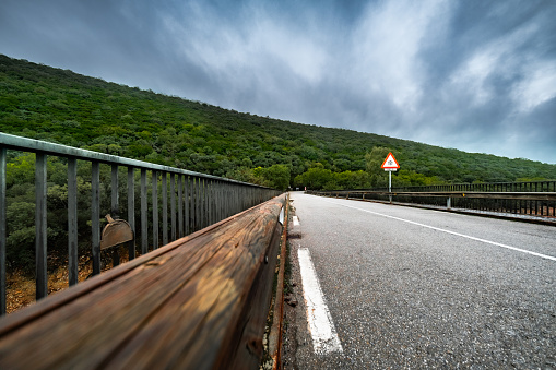 Tranquil Monfragüe Landscape, curvy road, rainy day, panoramic mountain view.