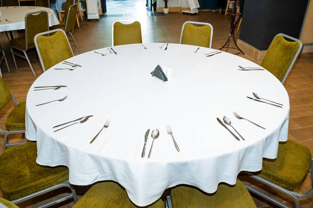 istock Serving in the restaurant is a white empty table, cutlery lies on the tablecloth, the interior of the catering establishment, preparation for the banquet, there are no people. fork on the table 1786240233