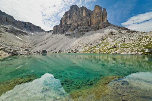 Shot taken on the Sella massif, which is placed between the Alta Badia and the Val Gardena (Gröden) Valleys. In this photo the famous Pisciadù Lake is in the foreground and reflections of the Sella Massif peaks around it are visible.