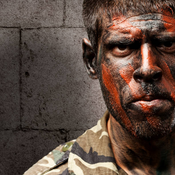 istock young soldier with camouflage paint looking very serious against 178625372