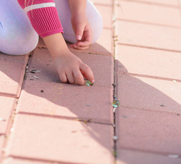 istock Girl Playing With Marbles 178625379