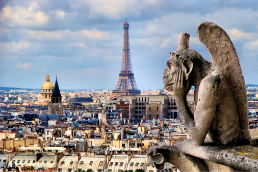 Gargoyles on Notre Dame Cathedral in Paris with view of cityscape below