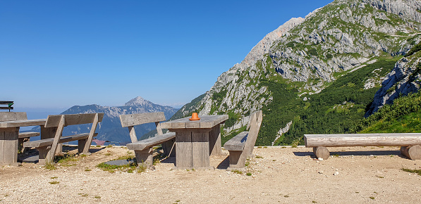 Empty tables and benches in mountains on sunny day, Kamnik - Savinja Alps, Slovenia