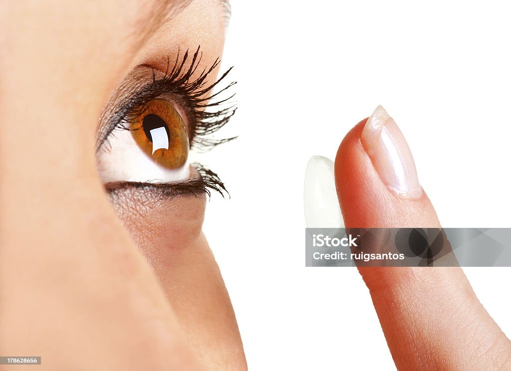 Close up of woman holding contact lens Closeup of a woman inserting a contact lens in her eye Contact Lens Stock Photo