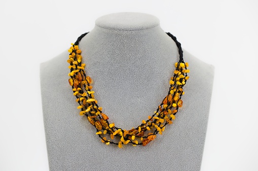 A polished amber necklace elegantly threaded on a black cord. The golden-brown hues of the Baltic amber create a warm, natural aesthetic. The minimalist design and sleek black cord highlight the gem's beauty. A fusion of organic simplicity and timeless elegance, this necklace is a stylish accessory with cultural and artisanal appeal.