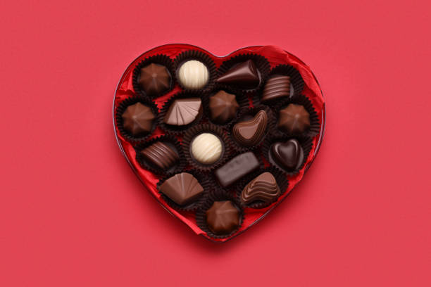 istock Heart shaped box with delicious chocolate candies on red background, top view 1786291361