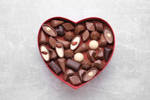 istock Heart shaped box with delicious chocolate candies on light grey table, top view 1786291928