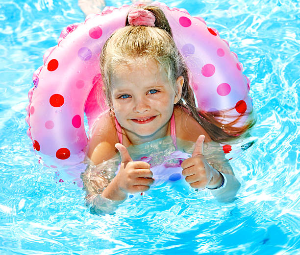 istock Child sitting on inflatable ring in swimming pool. 178629282