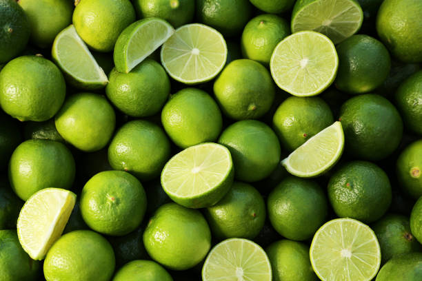 istock Whole and cut fresh ripe green limes as background, top view 1786294632