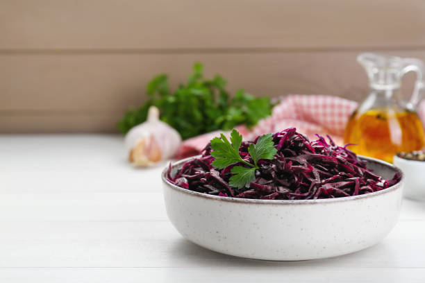 istock Tasty red cabbage sauerkraut with parsley on white wooden table. Space for text 1786294672