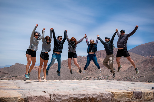 Group of happy friends jumping in the Pucará de Tilcara, Jujuy, Argentina. Group of tourists in Tilcara, Jujuy, Argentina. Group of friends in the north of Argentina