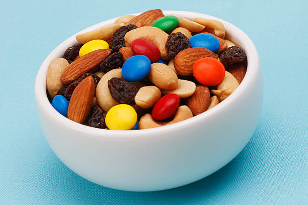 istock White bowl filled with trail mix on blue background 178629714