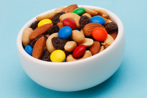 Trail mix in a white bowl on blue background