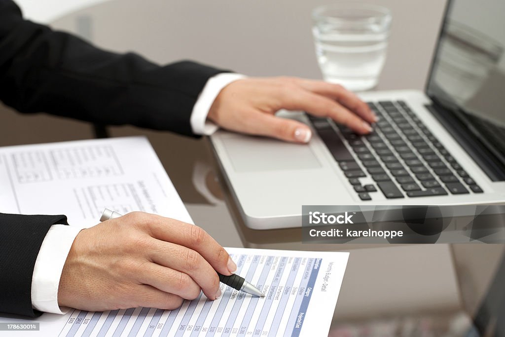 Female hands reviewing documents Close up of female hands reviewing accounting documents  on table. Document Stock Photo