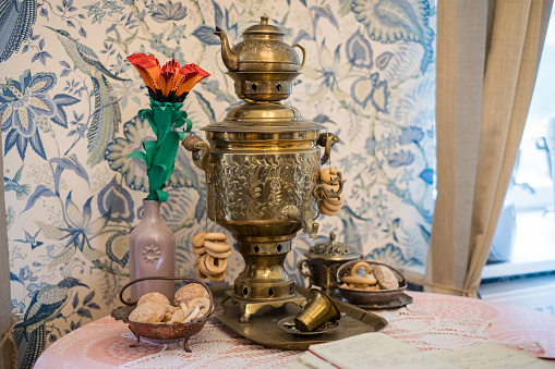 Traditional table setting with Samovar (English: self-brewer) used to make hot water for tea ceremony. Common kitchenware in every Russian household.