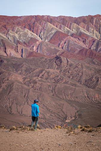 Small person in front of the immensity of The Hornocal, Jujuy, Argentina. Huge colorful mountains in the north of Argentina. Mountain of the fourteen colors The  Hornocal