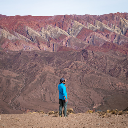 Small person in front of the immensity of The Hornocal, Jujuy, Argentina. Huge colorful mountains in the north of Argentina. Mountain of the fourteen colors The  Hornocal