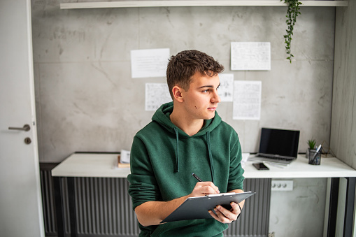 Portrait of a young student in his study