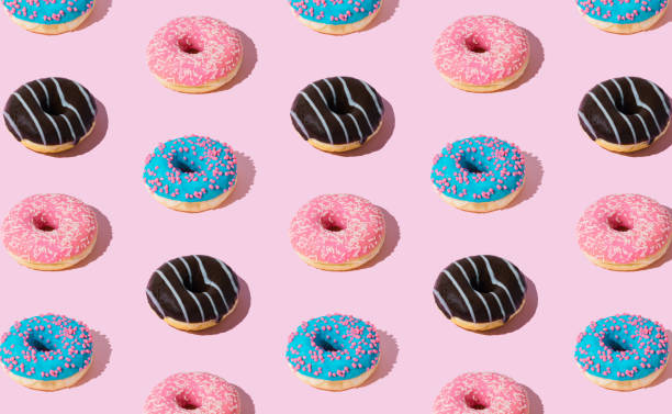 istock Creative pattern of colorful donuts on pastel pink background. Minimal concept. Trendy donuts pattern. Yummy food composition. Donuts aesthetic background. 1786317256