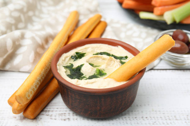 istock Delicious hummus with grissini sticks on white wooden table 1786317812