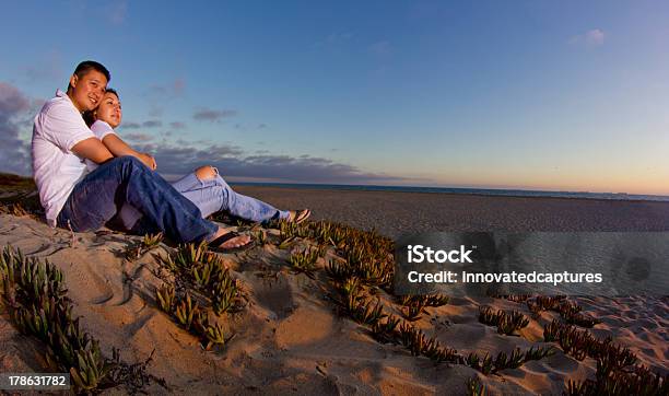 Asiática Pareja Viendo La Puesta De Sol En La Playa Durante La Puesta Del Sol Foto de stock y más banco de imágenes de Actividades recreativas