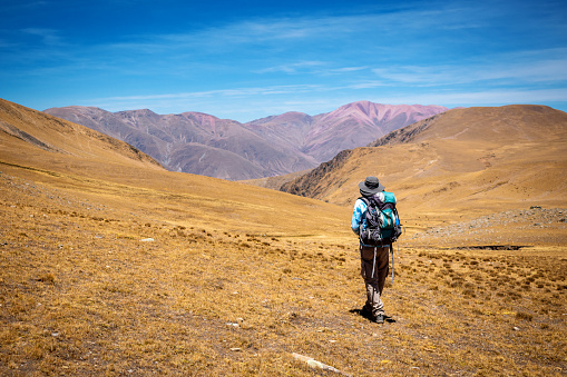 Mountaineer man achieving his goal.  Colorful mountains in northern Argentina. Trekking through the middle of the mountains in Argentina. Mountaineer walking in the mountains