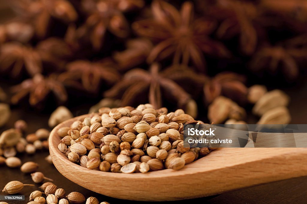 Coriander spice on a wooden spoon extreme close up Beech wood spoon with coriander  and spices background Anise Stock Photo