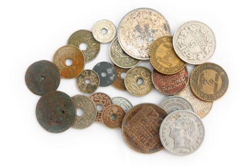 Several very old French coins, stacked on a white background