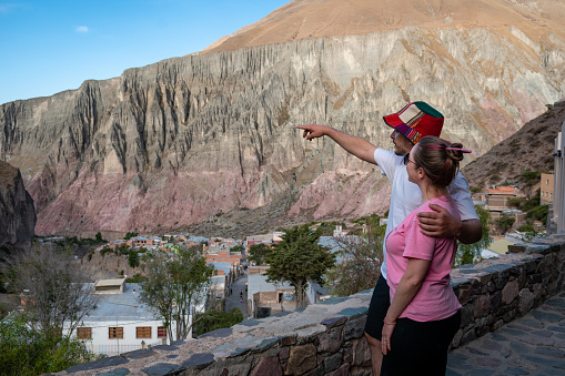 Young couple enjoying a beautiful mountain landscape. Happy wedding couple in Jujuy, Argentina. Young couple on vacation in northern Argentina. Bride and groom looking at the beautiful mountains