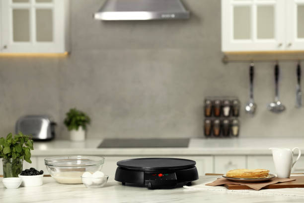istock Electric crepe maker and ingredients on white marble table in kitchen 1786334787