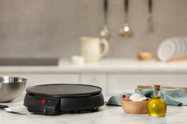 istock Electrical crepe maker and ingredients on white marble table in kitchen, space for text 1786335325