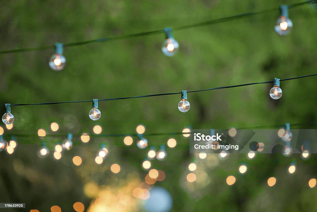 Decorative christmas lights for a back yard party Hanging decorative christmas lights for a back yard party Summer Stock Photo