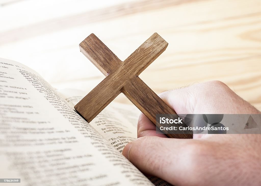 man holding the cross "man holding the cross in the hand ,with bible under" Bible Stock Photo