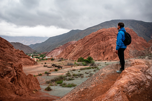 Young man on vacation in Purmamarca, Jujuy, Argentina. Young man admiring the landscape of northern Argentina. Tourist touring beautiful and colorful mountains of Purmamarca, Argentina