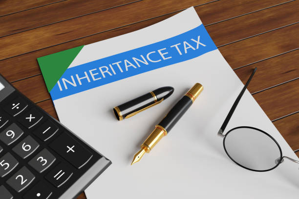 istock Calculator, fountain pen and spectacles on a bound document with a title inheritance tax on a wooden table 1786359700