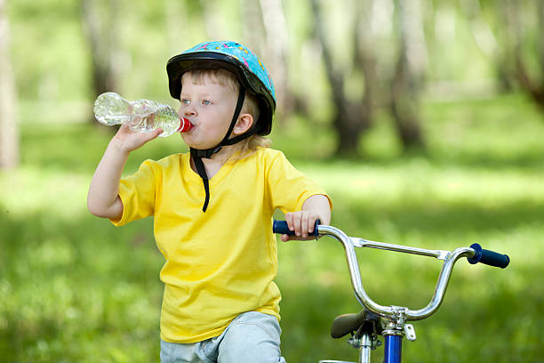 istock Cute child kid on bicycle and drinking  water fom bottle 178636140