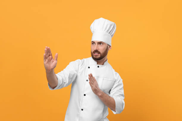 istock Emotional mature male chef on orange background 1786363513