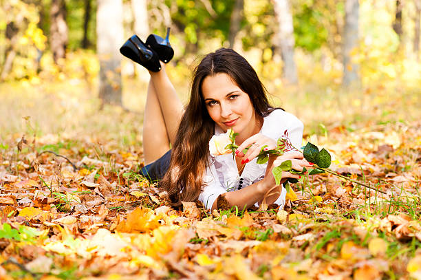 woman lying en las hojas otoñales - autumn leaf single flower flower fotografías e imágenes de stock