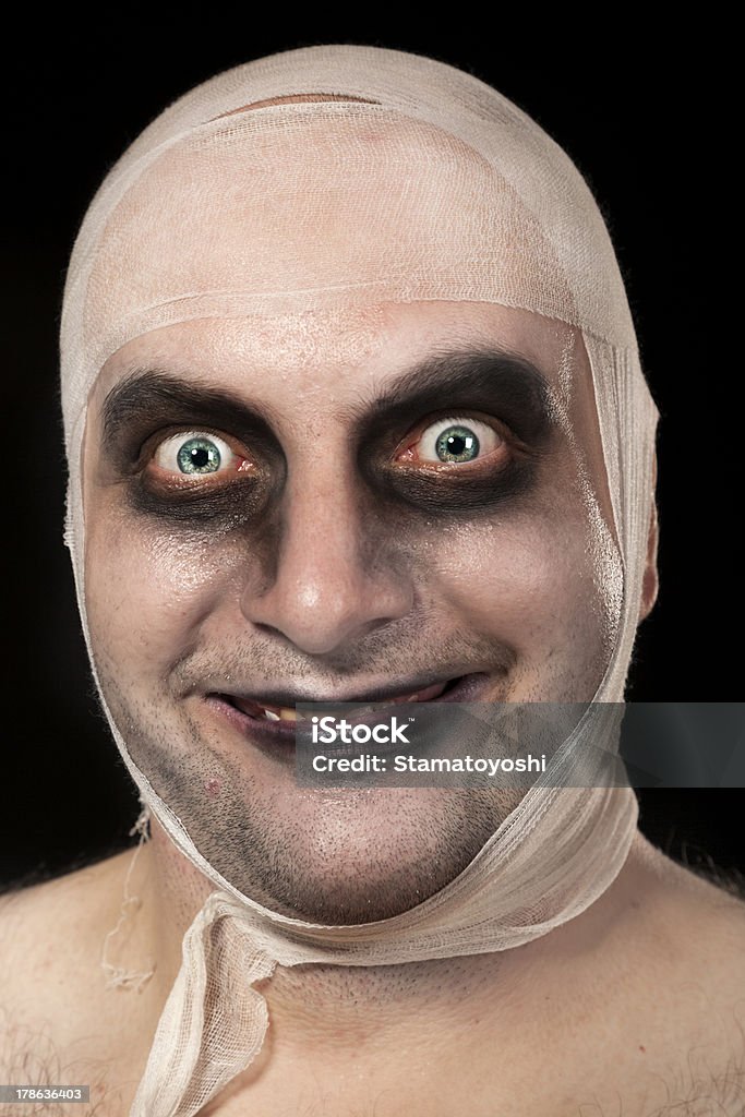 Funny zombie with bandages around his head Funny zombie with bandages around his head. Young man portrait with zombie make up Human Face Stock Photo