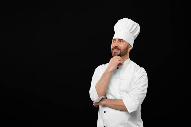 istock Smiling mature chef on black background, space for text 1786364054