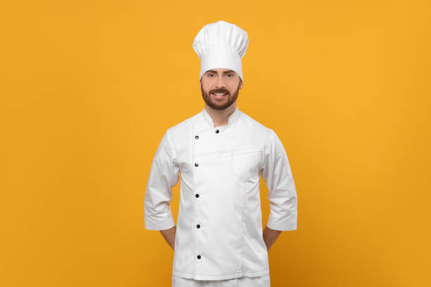istock Smiling mature male chef on orange background 1786366194