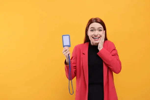 Photo of Emotional woman with vip pass badge on orange background. Space for text