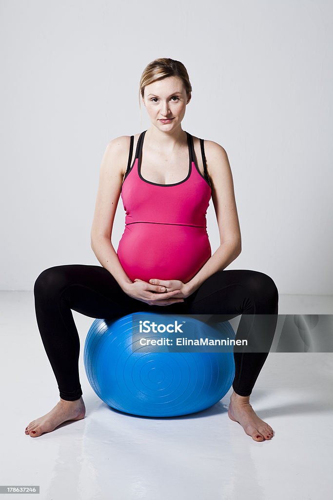 Pregnant woman relaxing Pregnant woman sitting on a fitness ball and relaxing Abdomen Stock Photo